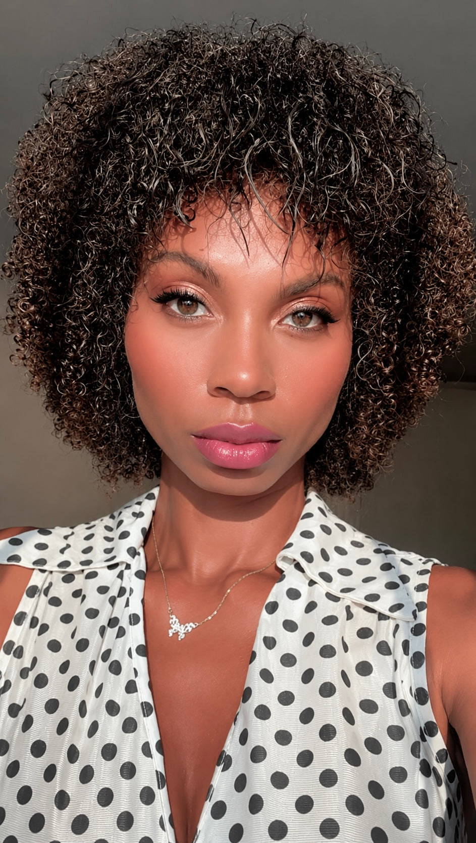 An African American beauty creator demonstrates the iLash Mafia Eyeconic DIY Lash kit. She holds up the lash box, displays the gold applicator tool and adhesive tube, and uses the tweezers to carefully apply individual lash clusters along her lash line before finishing and sealing the look.