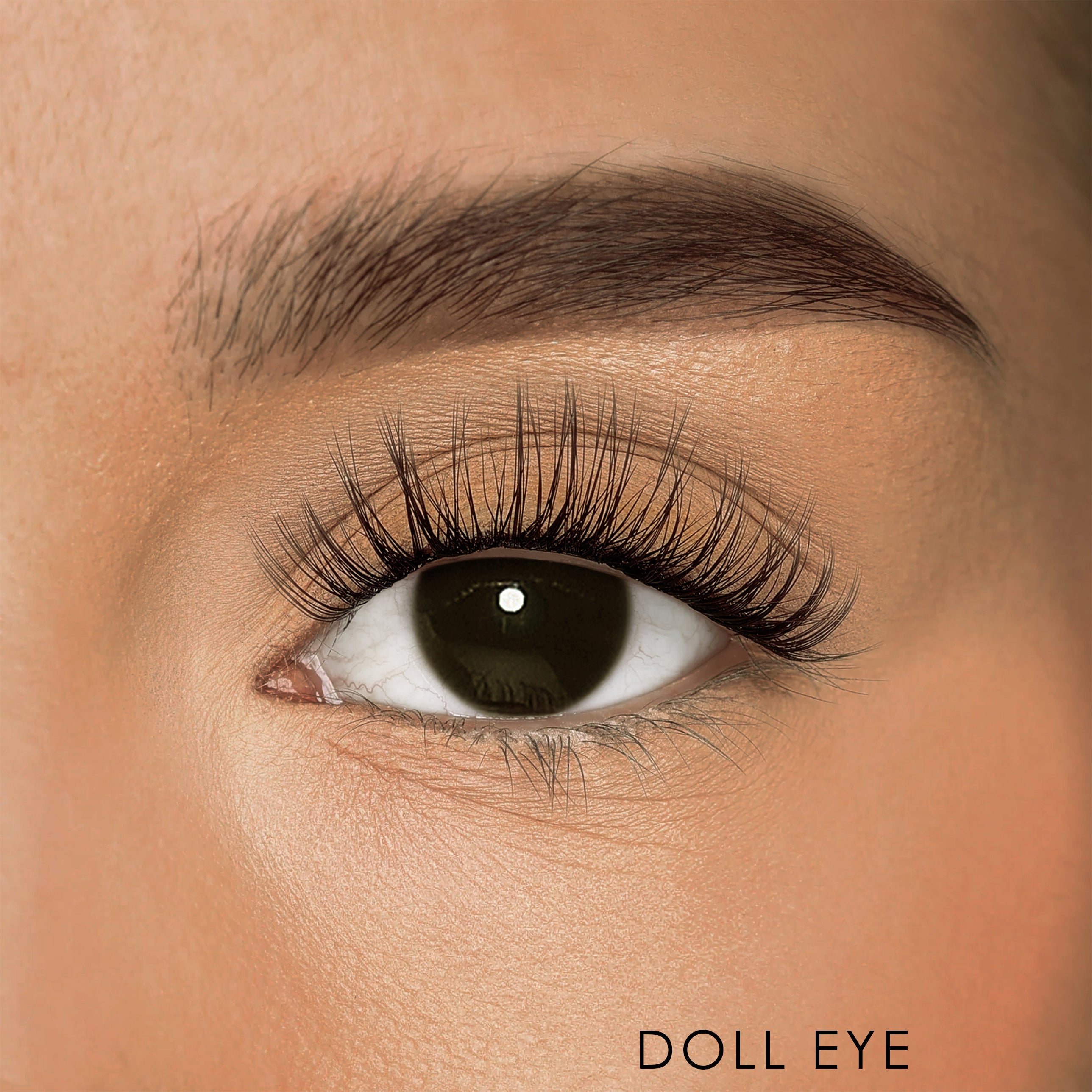 Extreme close-up of a model's eye showcasing iLash Mafia's DIY at-home eyelash extensions in the style 'Glow Up' mapped as a doll eye. The lashes feature a light textured volume, with the longest lengths in the center of the eye to create an open, rounded appearance. The text 'DOLL EYE' is printed in the bottom right corner.
