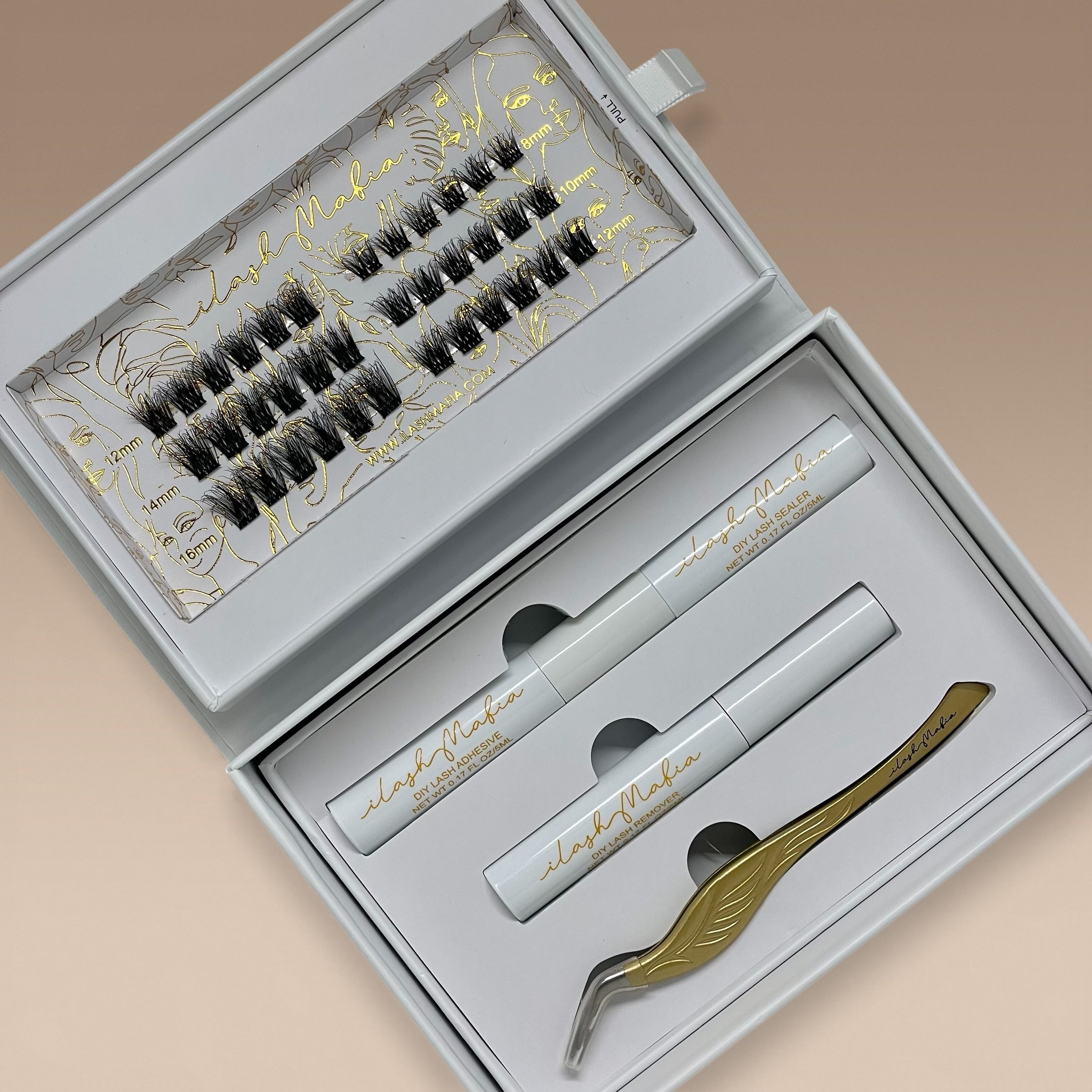 Luxury iLash Mafia DIY lash extension kit featuring soft wispy cluster lashes in 8mm–16mm lengths, DIY lash adhesive bond, lash sealer, lash remover, and gold application tweezers arranged inside a premium white magnetic gift box. Perfect for at-home lash extensions and reusable lash clusters